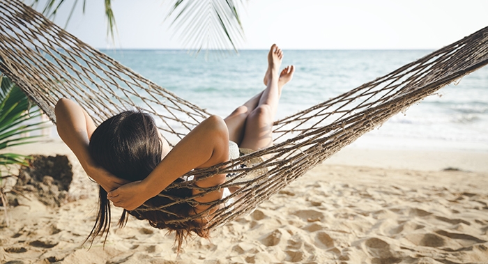 Enjoy relaxing in a hammock on the beach in sunny Treasure Island, Florida.